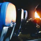 man looking on his sitting on plane seat