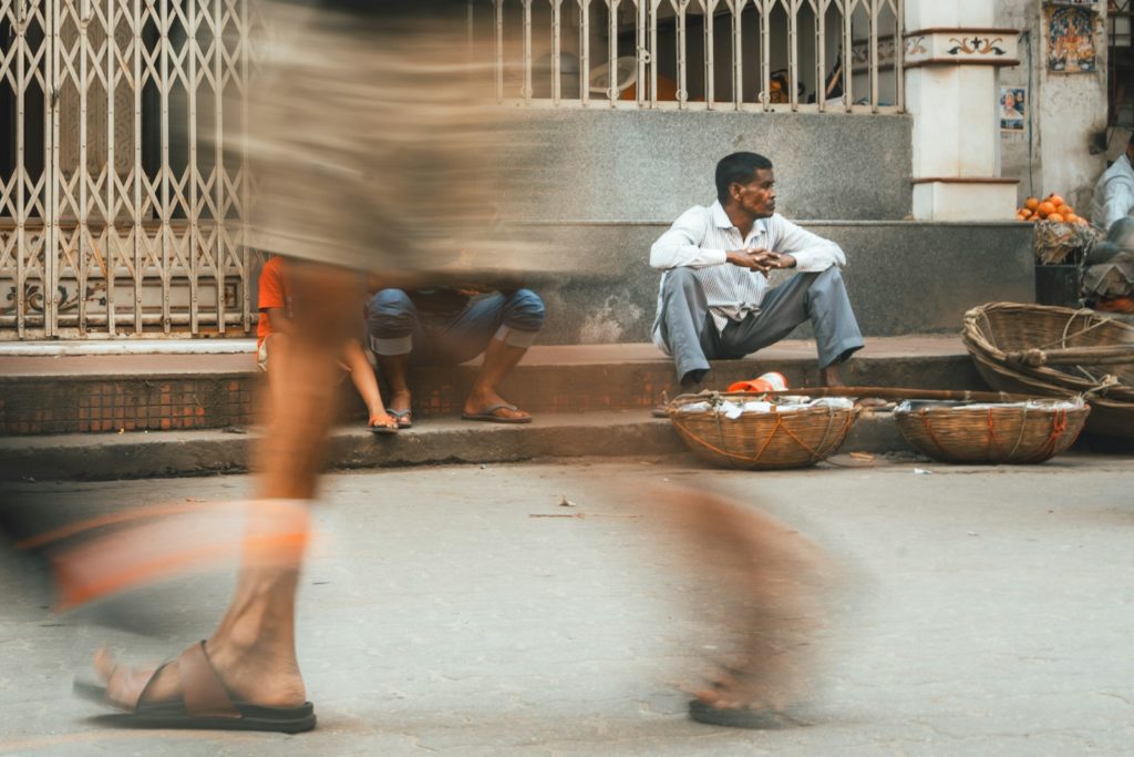 Una foto sfocata di un uomo seduto su un marciapiede